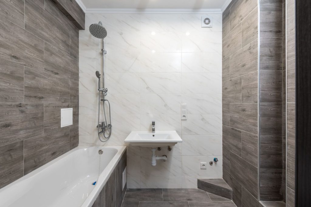 Badezimmer mit Badewanne, Fliesen und Armaturen während der Modernisierung