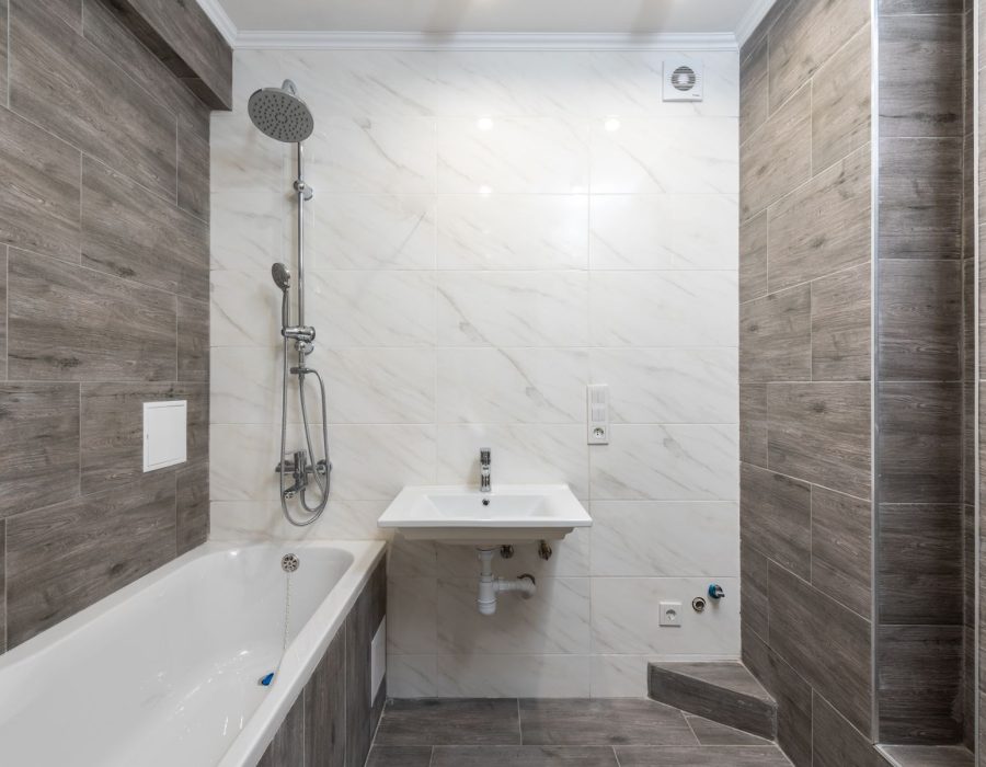 Badezimmer mit Badewanne, Fliesen und Armaturen während der Modernisierung